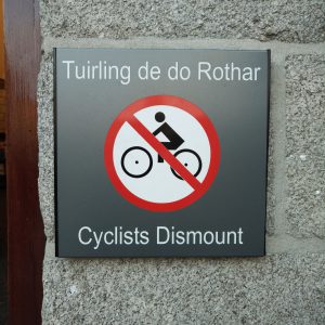 ein Schild mit der Aufschrift "Cyclist Dismount" / "Tuirling de do Rothar"